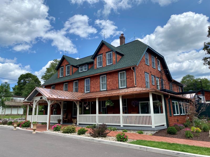 The exterior of the Eagles Mere Inn, featuring dark cedar shakes and a green roof