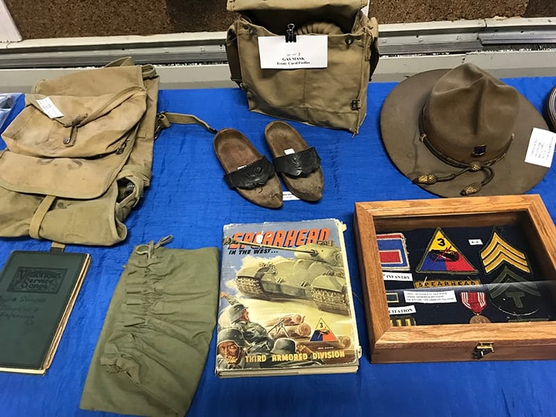 A military exhibit with a hat, shoes, knapsacks, patches, and books at the Wyoming County Historical Society.