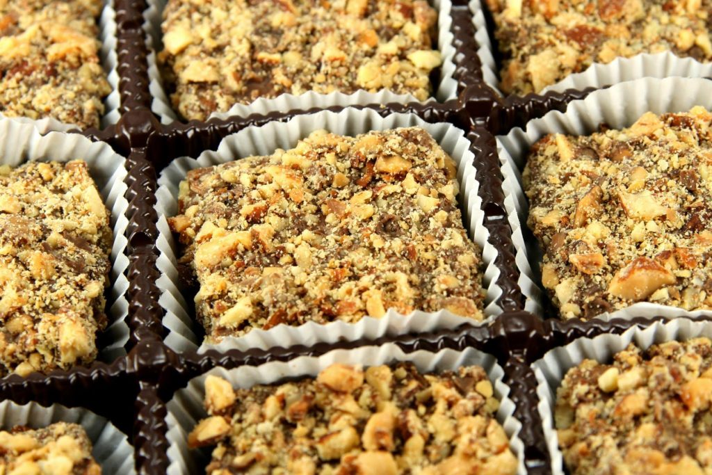 Buttercrunch candies, featuring chocolate squares topped with crushed almonds.
