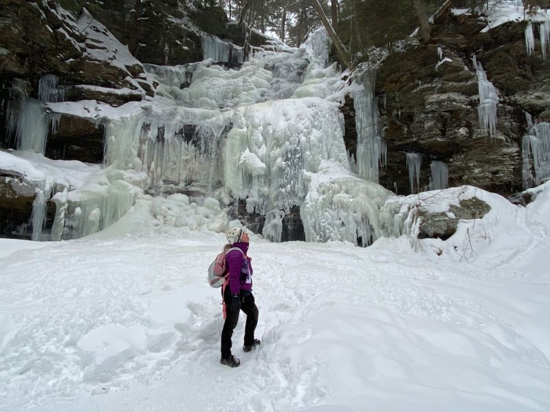 A women looks up at the frozen waterfalls at Ricketts Glen State Park