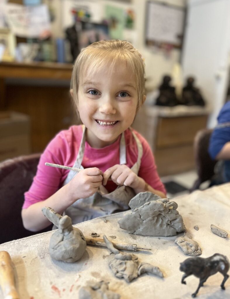 A girl makes clay animals at the Dietrich Theater's children's pottery class
