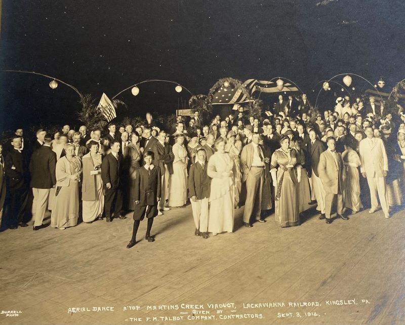 A black-and-white photo of a formal party on top of the viaduct