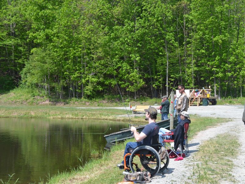 Teens and adults fish from the shoreline during the veterans and special needs fishing derby
