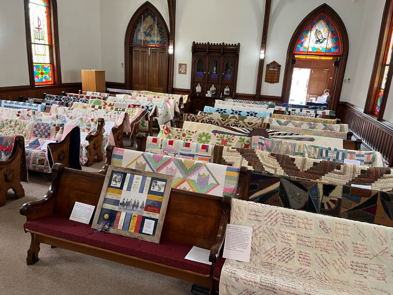 Quilts displayed over the backs of pews at Camptown Community Church
