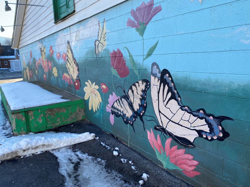A mural featuring yellow swallowtail butterflies in a field of flowers.