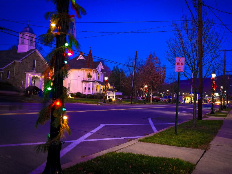 Streetlamp decorated with Christmas lights and church in the background